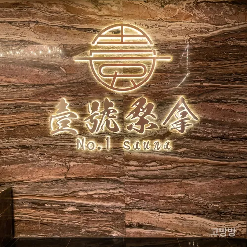 붉은 결 대리석 벽에 금빛 로고가 새겨진 넘버원 사우나 사인월, 마카오